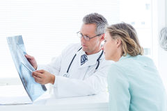doctor-having-conversation-his-patient-holding-xray-medical-office-53047421.jpg
