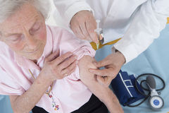 doctor-injecting-vaccine-to-senior-woman-49701307.jpg